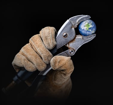 Worker In Construction Gloves Holding Planet Earth with  Vise-grip Wrench photo