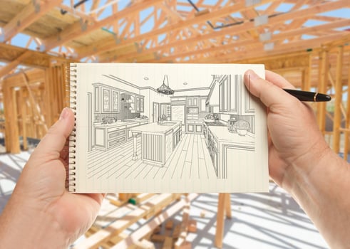 Male Hands Holding Pen and Pad of Paper with Custom Kitchen Illustration Inside Construction Framing. photo