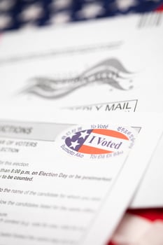 Vote-By-Mail Ballot Envelope and Voting Instructions Laying On American Flag photo