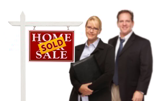 Businesswoman and Businessman Behind Real Estate Sign Isolated photo