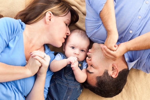 Mixed Race Family with Baby Playing on the Blanket photo