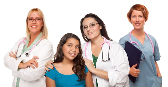 Hispanic Female Doctor with Child Patient and Colleagues Behind photo