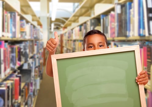 Hispanic Boy with Empty Chalk Board in Library photo