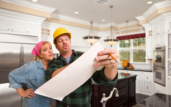 Contractor Discussing Plans with Woman Inside Custom Kitchen Interior photo