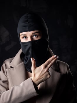 Portrait of a girl in a black balaclava and beige coat. photo