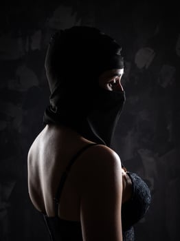 Portrait of a girl in a black balaclava and a black bra. photo