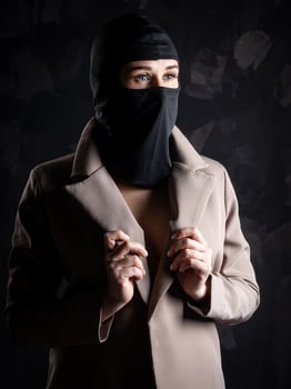Portrait of a girl in a black balaclava and beige coat. photo