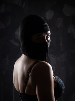 Portrait of a girl in a black balaclava and a black bra. photo