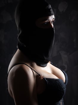 Portrait of a girl in a black balaclava and a black bra. photo