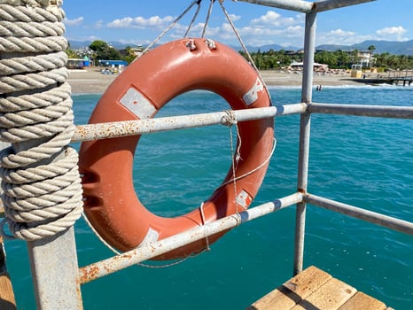 Round non-sinking red lifebuoy for safety to save the lives of drowning people tourists against the background of the sea in a warm eastern tropical country southern paradise resort photo
