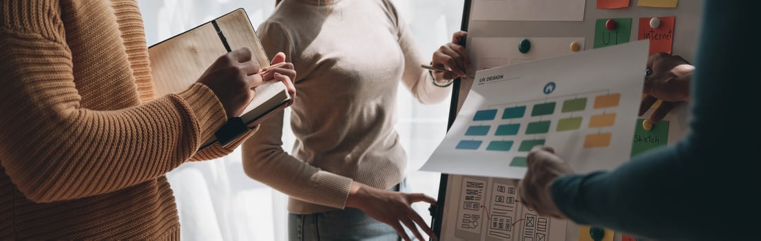 Close up ux developer and ui designer brainstorming about mobile app interface wireframe design on table with customer breif and color code at modern office.Creative digital development agency photo