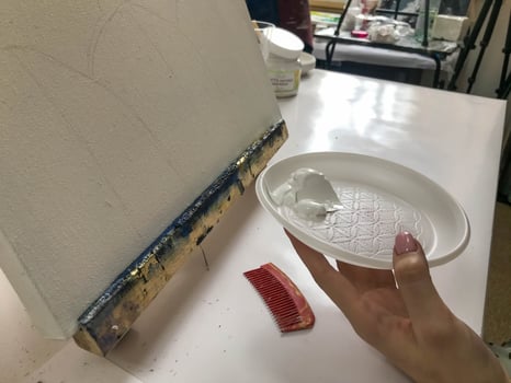 Woman painter creating fluid acrylic abstract painting in art therapy class, dropping paints on canvas photo