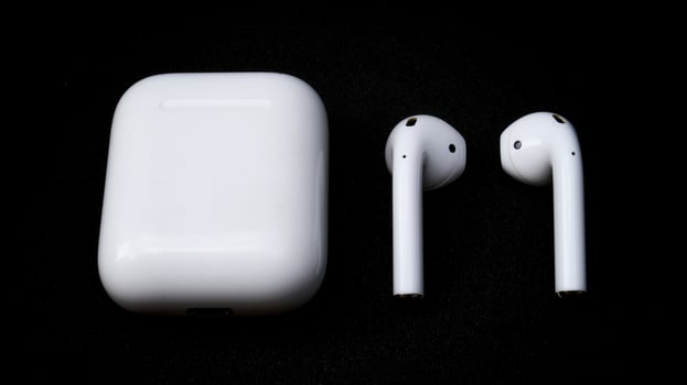 White ear pods with black isolated background, detail close up wireless earphone for daily smart phone entertainment and connectivity. photo