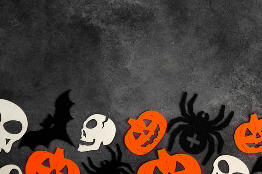 Halloween banner with bats,spiders,pumpkins and skulls on dark concrete background. photo