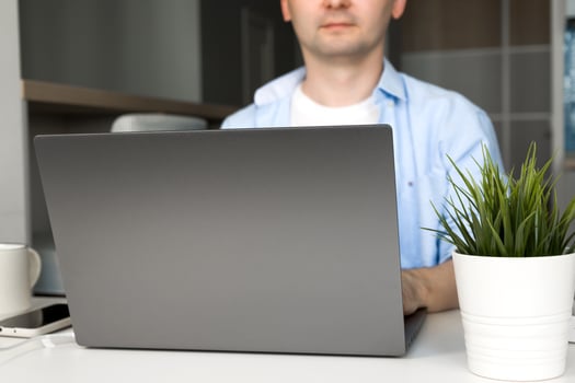Young asian male working on laptop wearing.Remote work or education.Selective focus on laptop photo