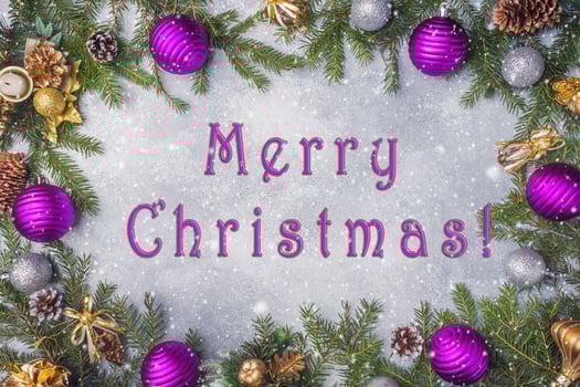 Christmas decorations, toys and spruce branches on grey background. New year's concept of the Inscription merry Christmas photo