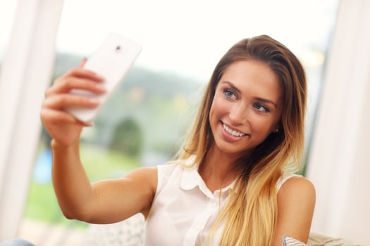 Woman on couch in living room taking selfie photo