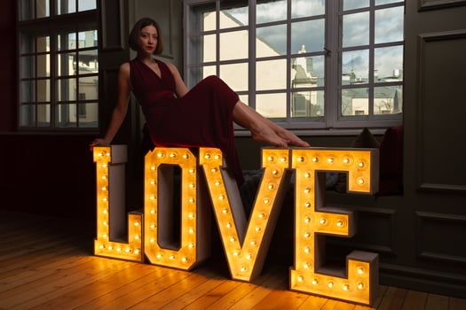 Women in red dress laying on letters LOVE photo