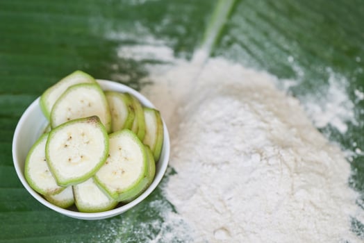 banana powder on bowl and raw banana - banana fruit on leaf background, alternative flour, homemade green banana flour for herbal medicine nature herb photo