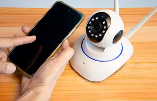 man using smart phone with ip camera photo