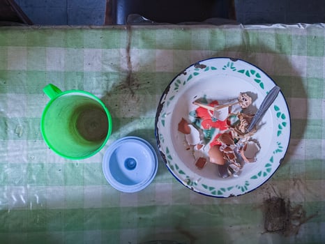 The dining table is in a mess. A messy dining table with used dishes and full of food scraps that have not been cleaned. real life. year-end photo