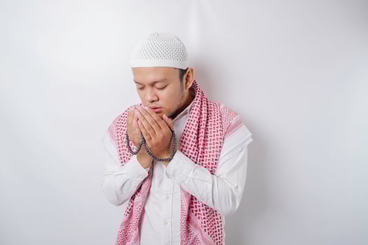 Happy handsome Asian Muslim man is praying to God. photo