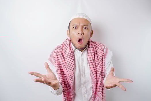 A portrait of a shocked Asian Muslim man isolated by a white background photo