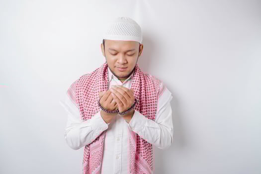 Happy handsome Asian Muslim man is praying to God. photo