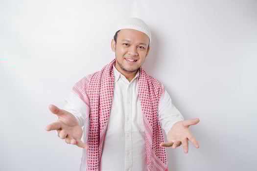 Young Asian Muslim man presenting an idea while smiling on isolated white background photo