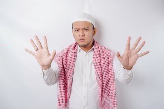 Beautiful Asian Muslim man with hand gesture pose rejection or prohibition with copy space photo