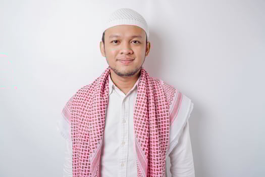 A portrait of a happy Asian Muslim man smiling isolated by white background photo
