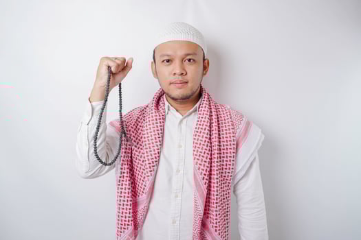 A young Asian Muslim man with a happy successful expression isolated by white background photo
