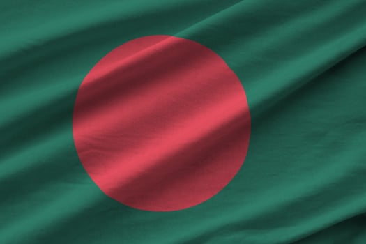 Bangladesh flag with big folds waving close up under the studio light indoors. The official symbols and colors in banner photo