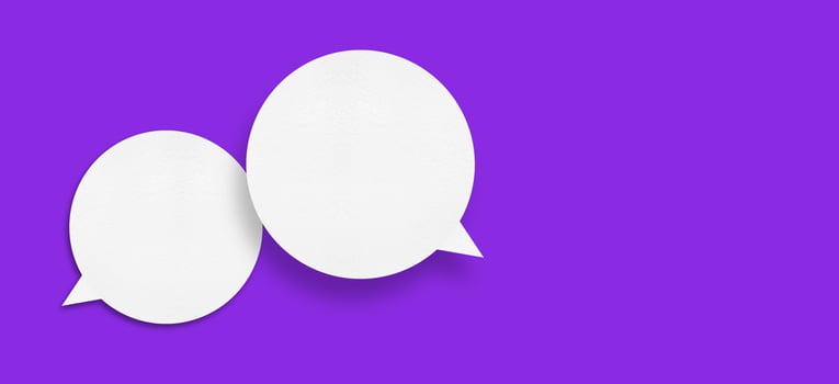 White paper in the shape of speech bubbles against a purple background. communication bubbles photo