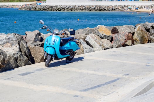 motorcycle near sea coastline. Scooter parked near the beach. photo