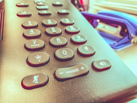Office phone with large buttons on wooden table. photo