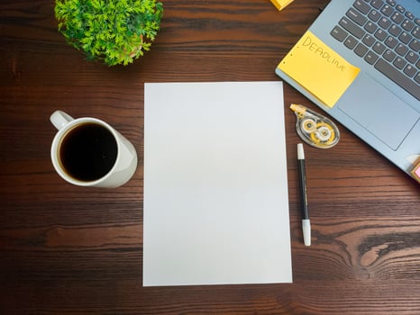Flat lay, mock up paper. workspace in the background of the office desk from the top view.  with blank white paper, laptops, office supplies, pencils, green leaves, and coffee cups in a wooden table. photo