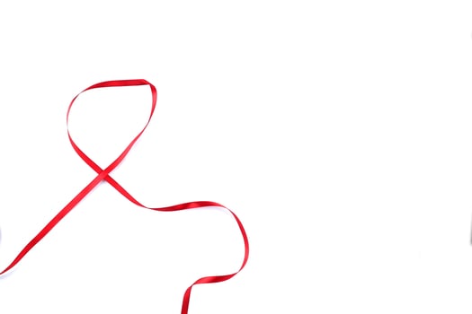 Red Support Ribbon isolated on white background. World aids day and national HIV AIDS and aging awareness month with red ribbon. copyspace area photo