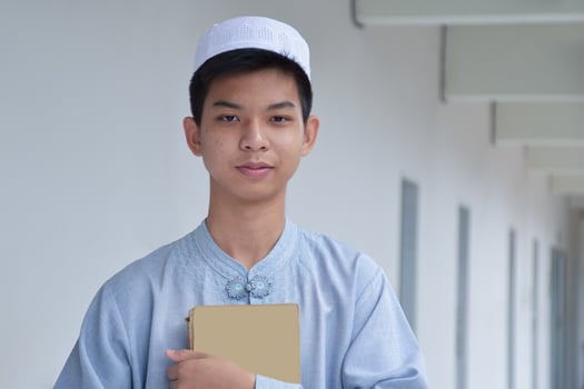 Portrait young southeast asian islamic or muslim boy in white shirt and hat, isolated on white, soft and selective focus. photo