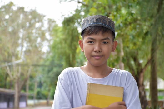 Portrait young southeast asian islamic or muslim boy in white shirt and hat, isolated on white, soft and selective focus. photo