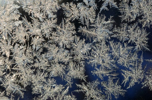 Snowflakes frost rime macro on window glass pane photo