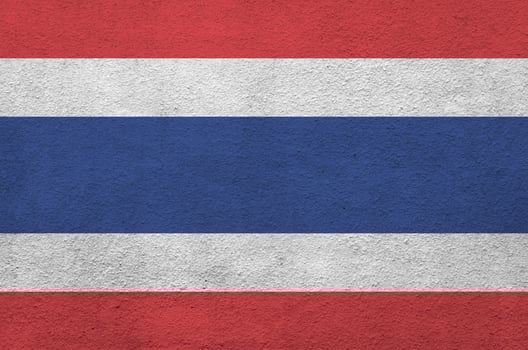 Thailand flag depicted in bright paint colors on old relief plastering wall. Textured banner on rough background photo