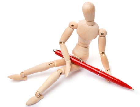 Small wooden dummy and ballpoint pen photo