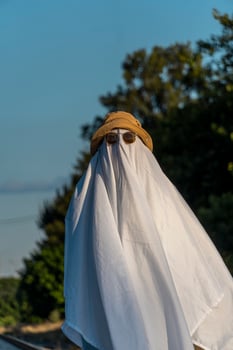 White ghost with black eyes, made from a bedsheet. whit hat photo