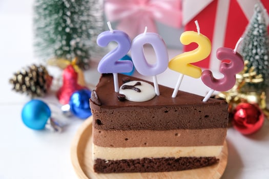 Chocolate cake with numbers 2023  and accessories for Christmas and new year event isolated on pink background. photo