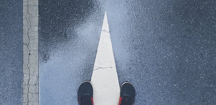 Top view or Flat lay of sneaker or running shoes on wet street or road with white end of direction sign and line with copy space. Joking and Exercise after raining in vintage tone. photo