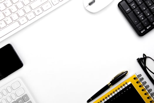 top view of modern white office desk with computer keyboard, blank notebook page and other equipment on white background. Workspace concept, workspace management style, business design space with copy photo