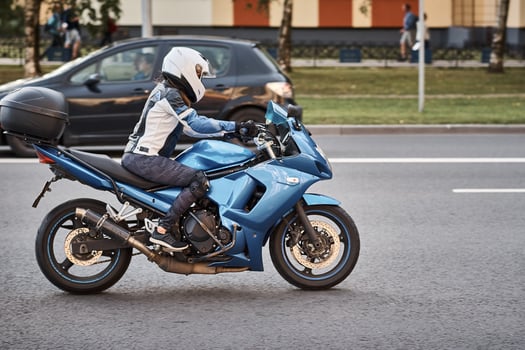 Motorcycle driver riding bike in the city street photo