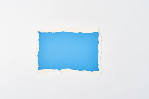 Ripped blue paper torn edge sheet on a white background. photo