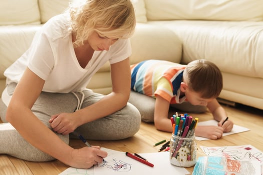 Happy mother and son are drawing together at home photo